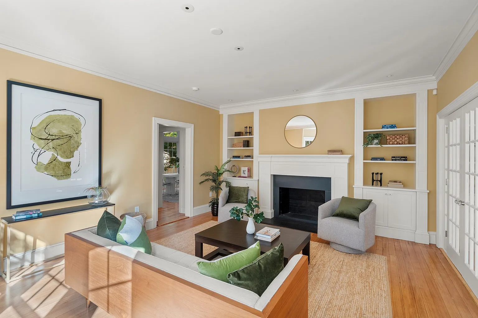 A gas fireplace is centered between built-in shelving, with the sofa and lounge chairs arranged to gather around the fire.