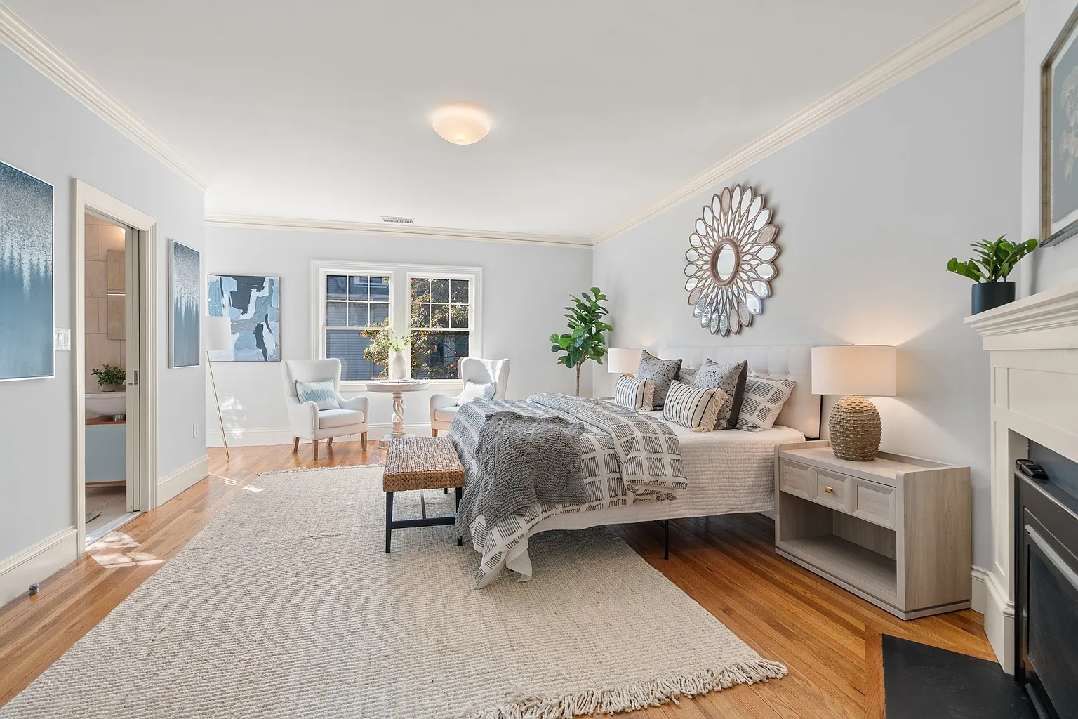 A secondary suite has a similar layout but on a smaller scale, with a gas fireplace set along one wall and the bed positioned next to a small sitting area near the windows.
