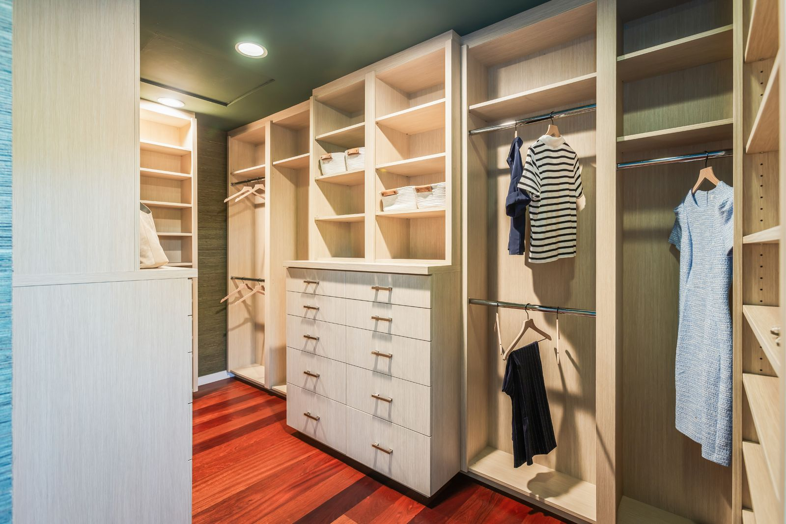 Custom cabinetry lines both sides with a mix of hanging sections and open shelving.