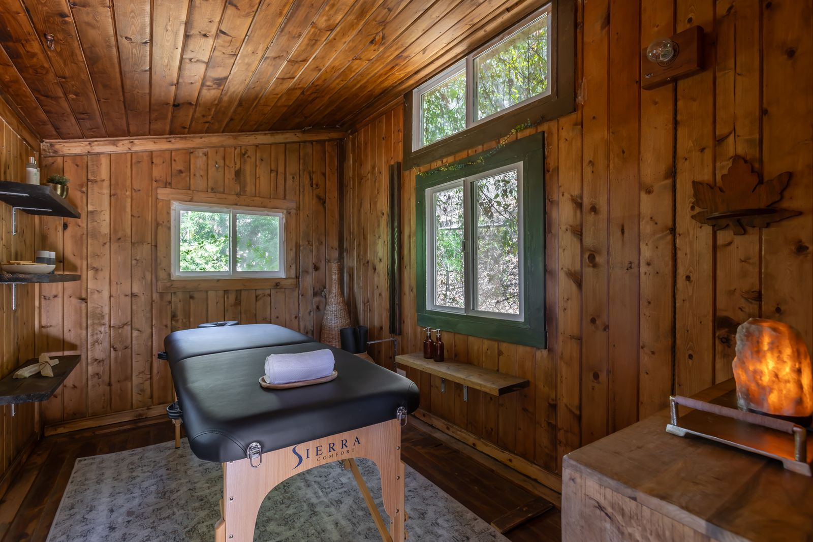 The second structure is much more enclosed and rustic, with wood paneling wrapping the walls and ceiling around smaller windows.