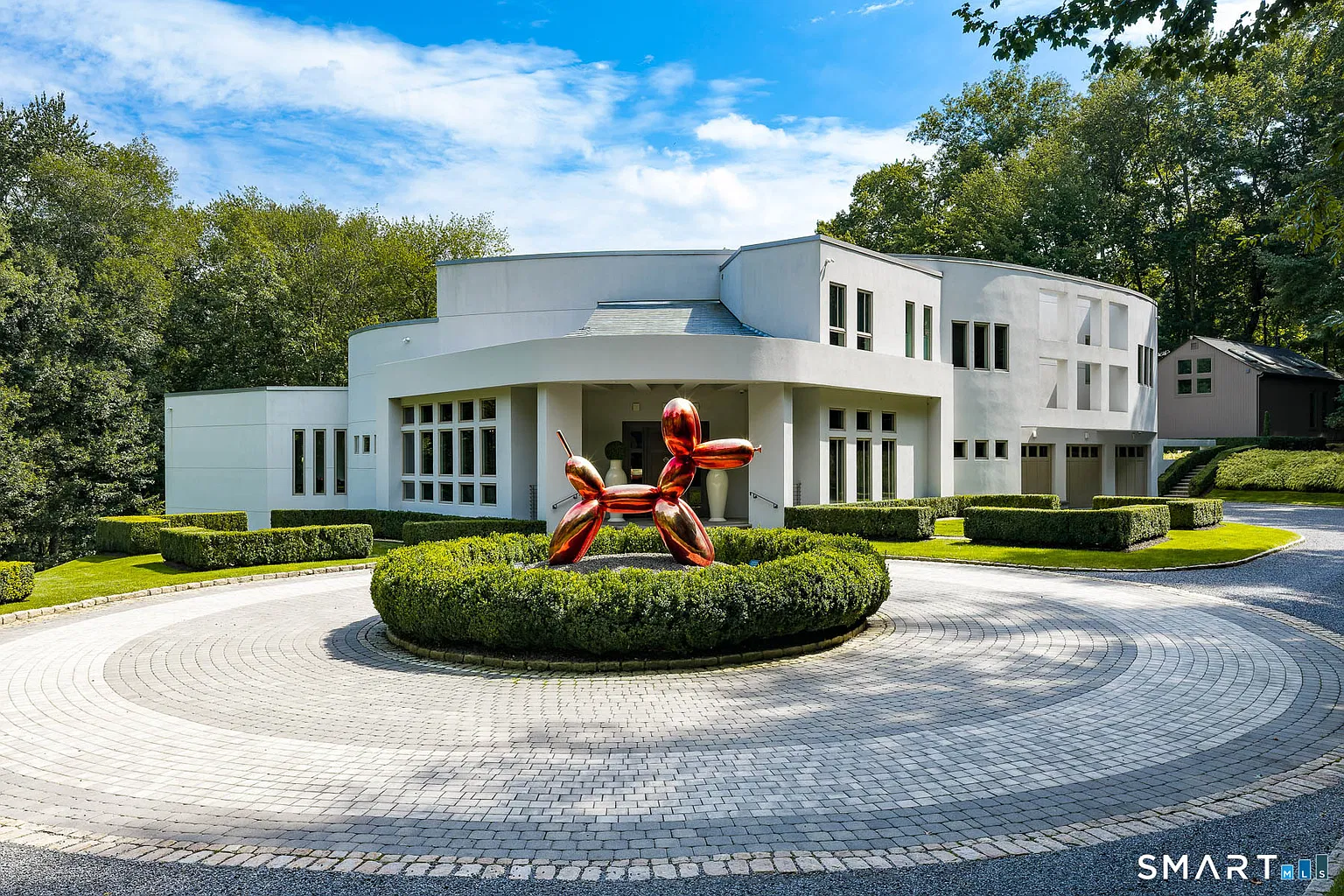 Round driveway circling around a red balloon animal sculpture in the center.