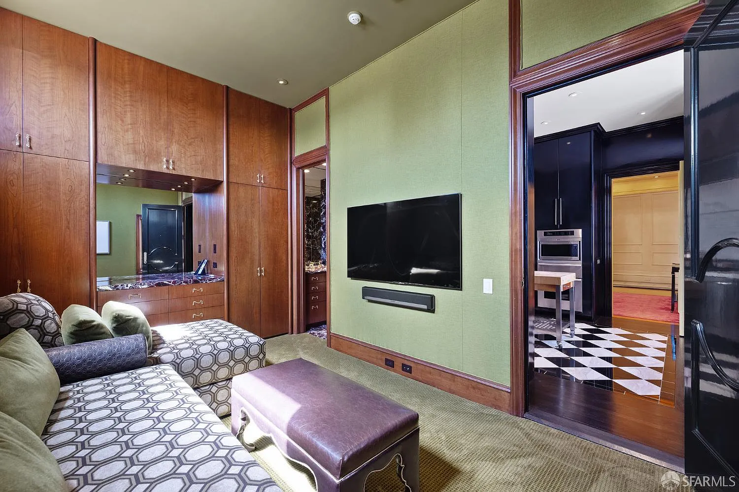 The first bedroom is designed as a compact guest suite, with built-in wood cabinetry filling one wall around a small vanity.