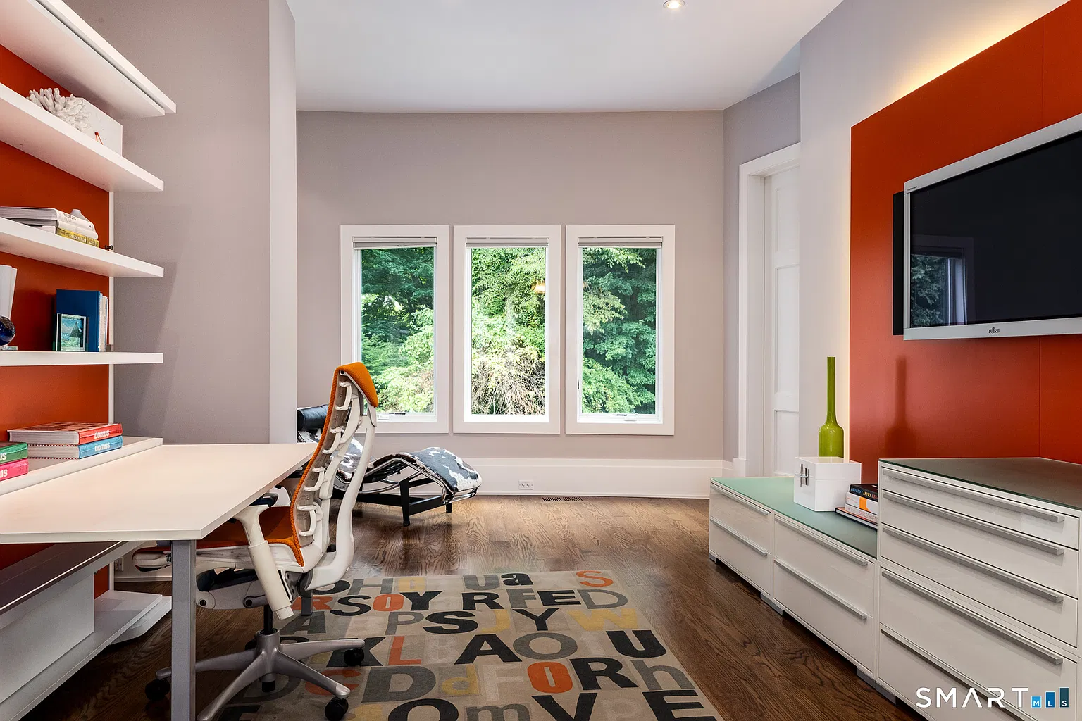 A second office includes a long desk beneath a wall of open shelving.