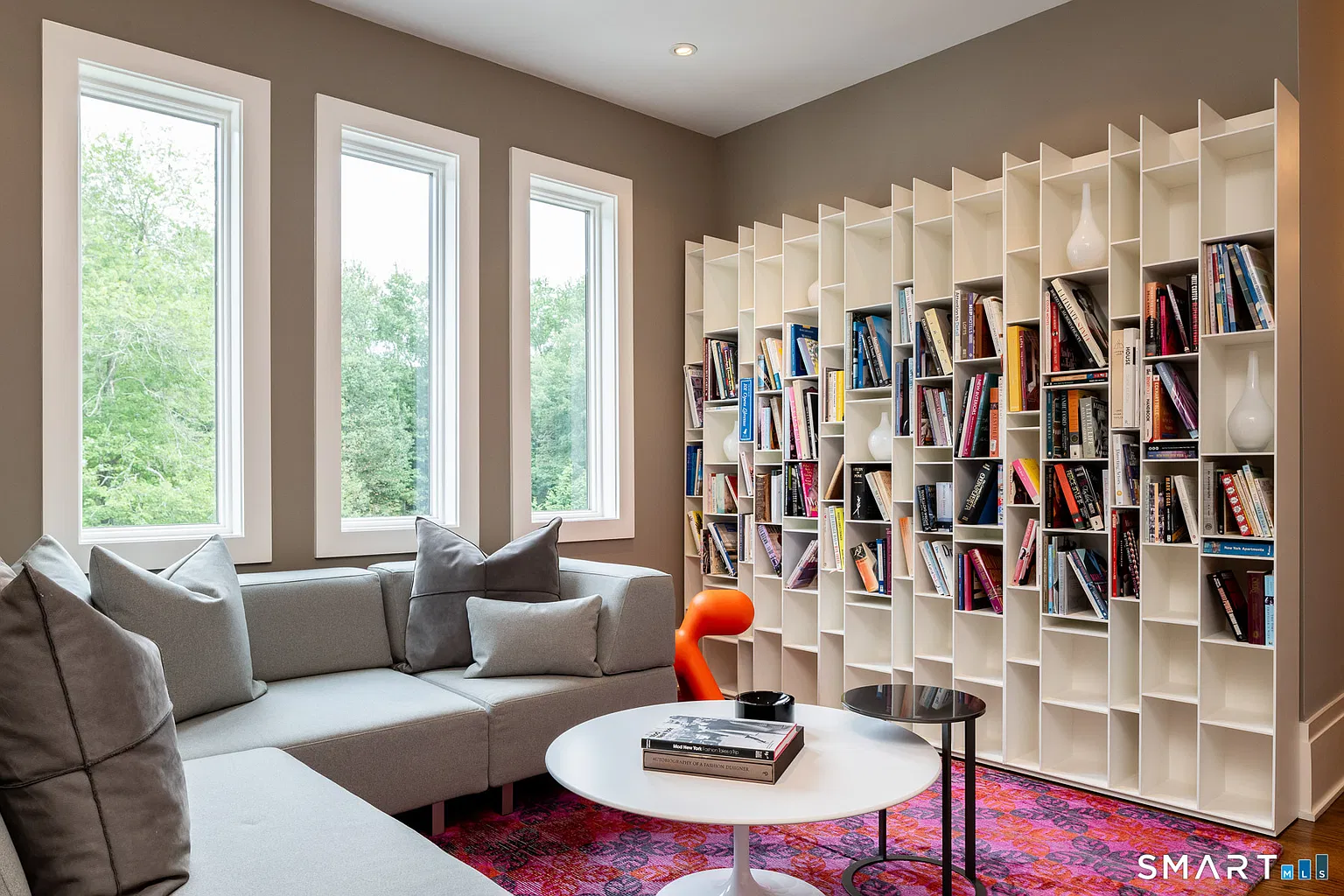 Also on the upper floor, the library has a full wall of geometric shelving that rises nearly to the ceiling. 