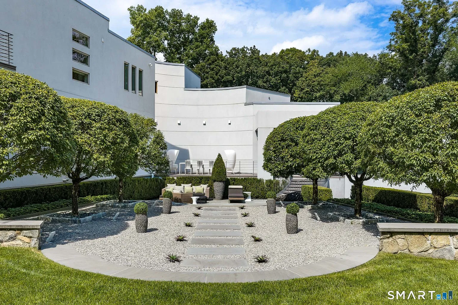 A Zen-inspired garden centered on a gravel court with stepping stones forming a straight path through the middle.