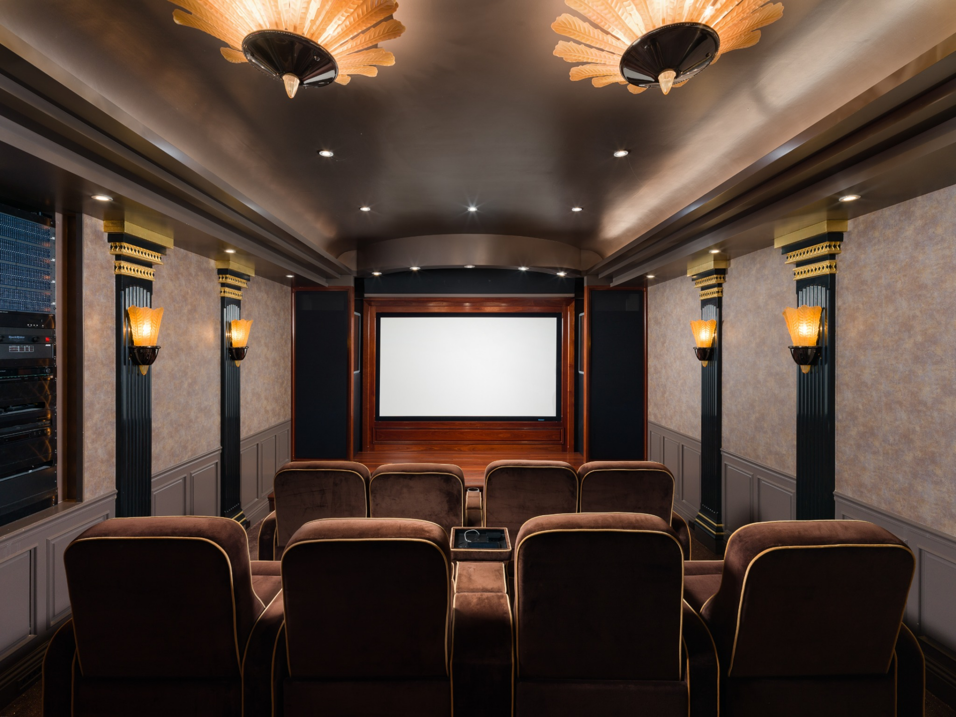 Tiered rows of reclining seats facing a large projection screen.