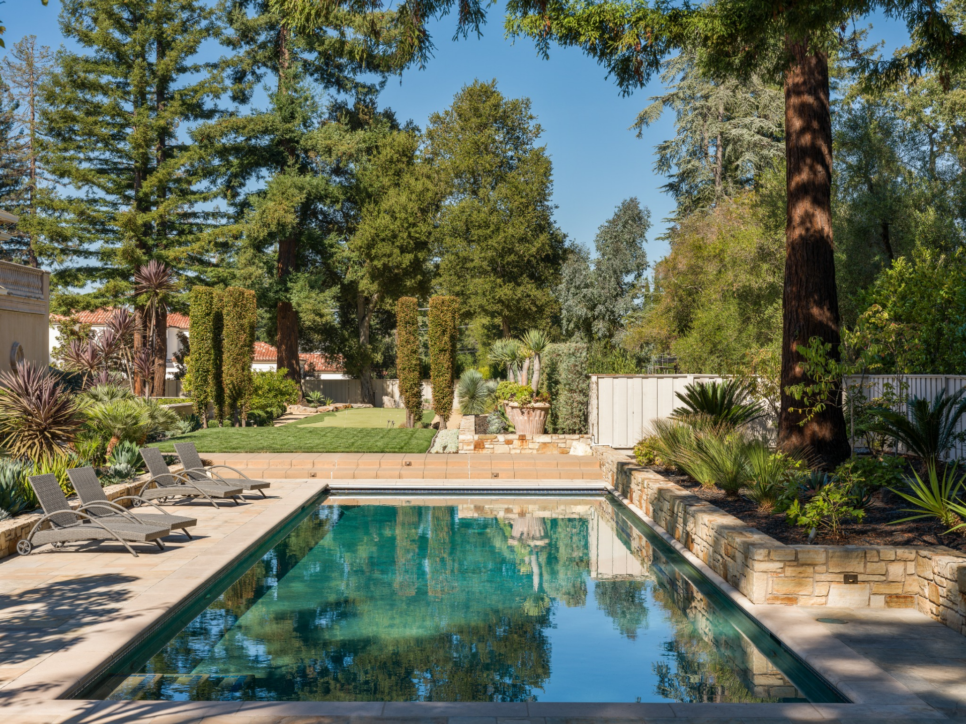 25-yard lap pool set into a wide stone terrace lined with lounge chairs.