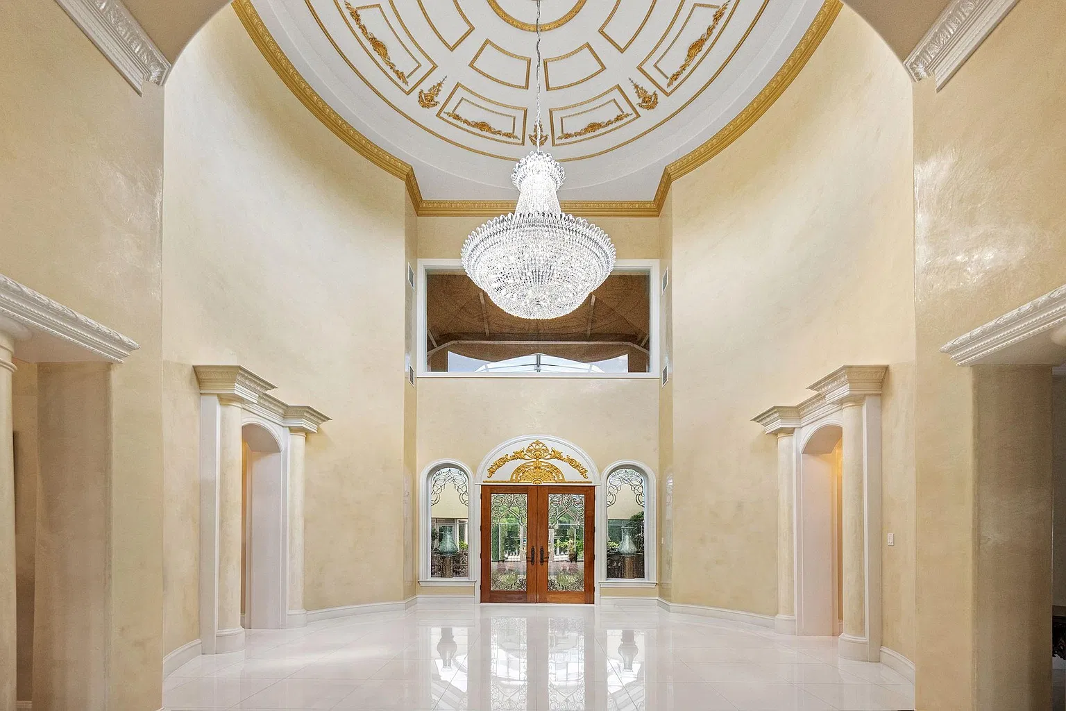 Past Foreman’s front door, the foyer opens beneath a soaring domed ceiling with a large crystal chandelier hanging from the center.