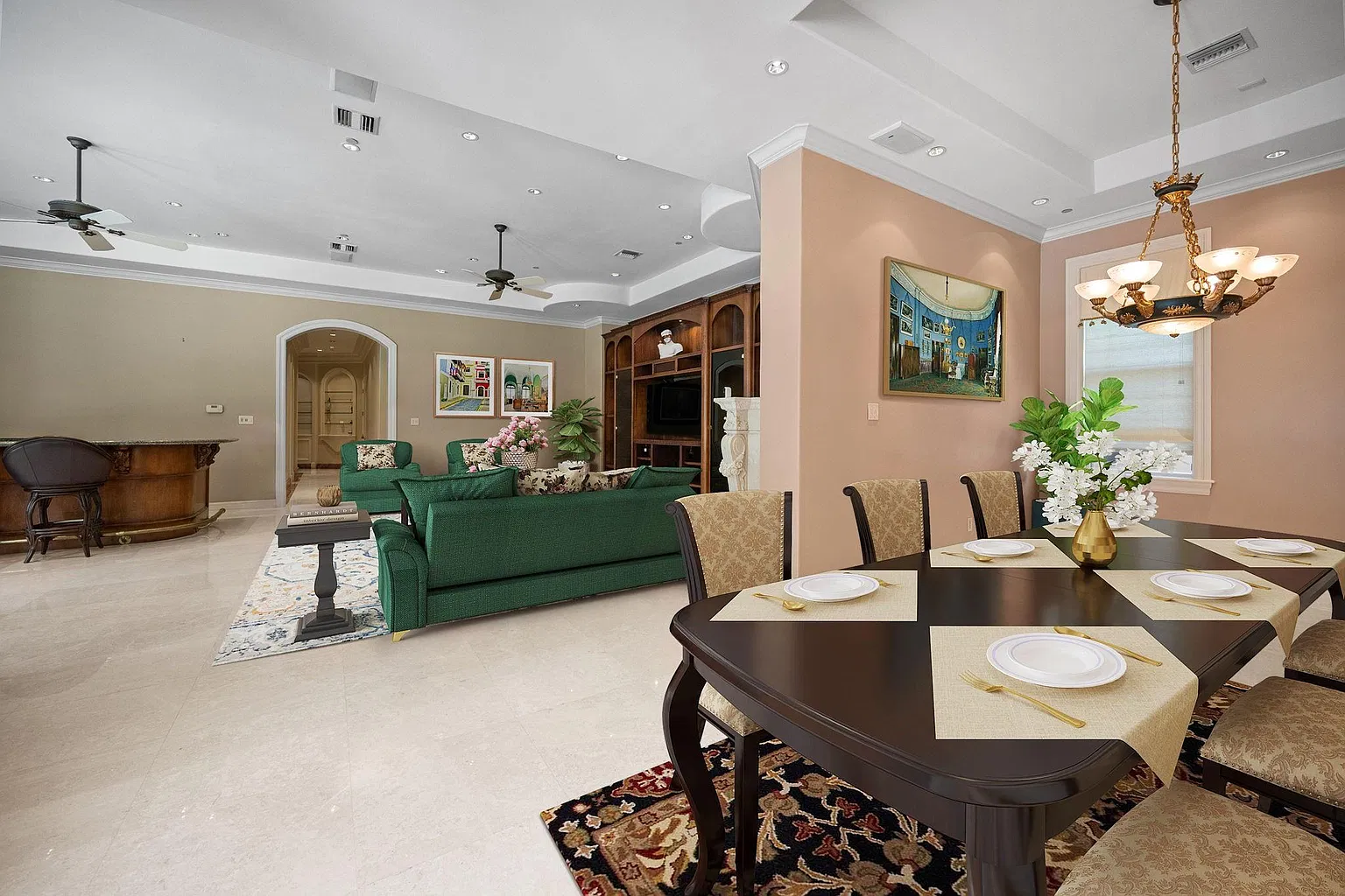 A media lounge has dark green furniture framing a built-in entertainment wall, with a curved bar sitting across from it and a dining table on the other side of the room.