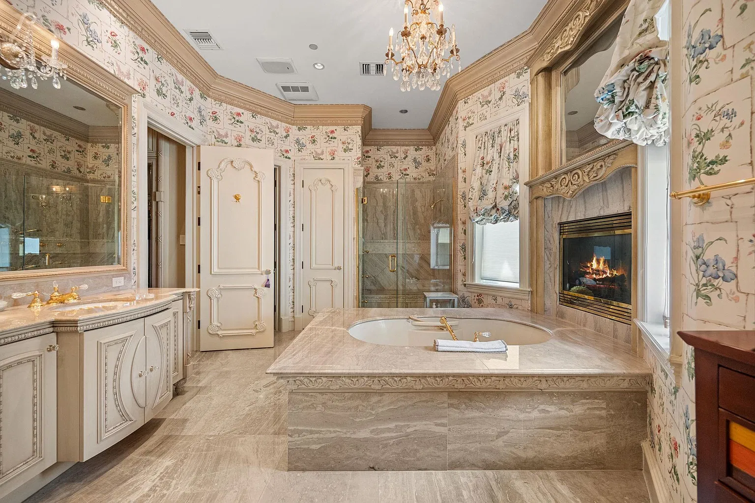 The vanity sits across from a tub beneath an oversized mirror, while behind the tub, a glass-enclosed shower sits in the back corner.