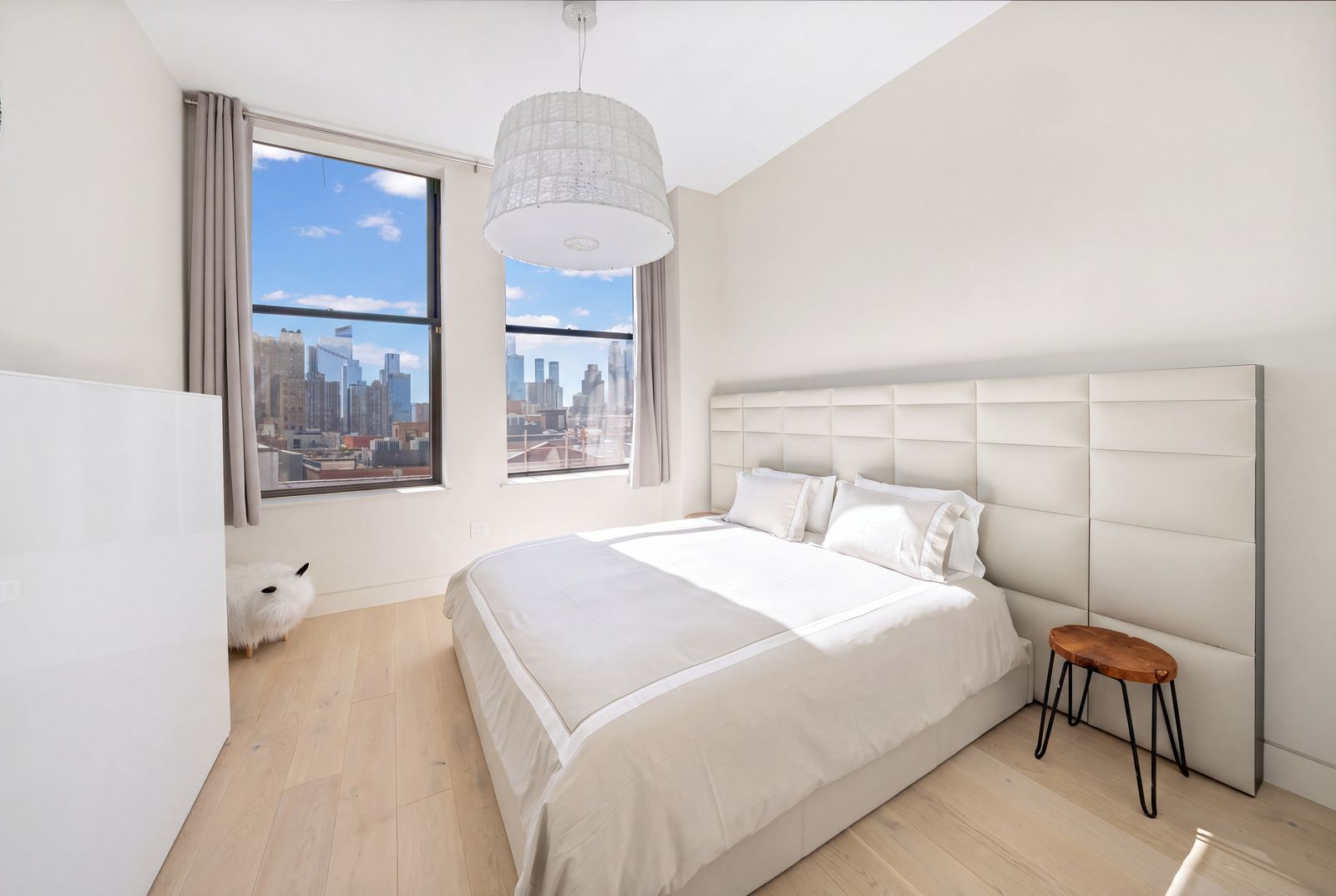 The second suite's bed sits against an upholstered headboard that extends across the wall.