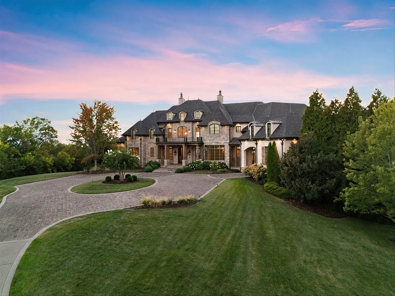 A circular driveway curves across the front of the estate before leading to a covered porte-cochère.