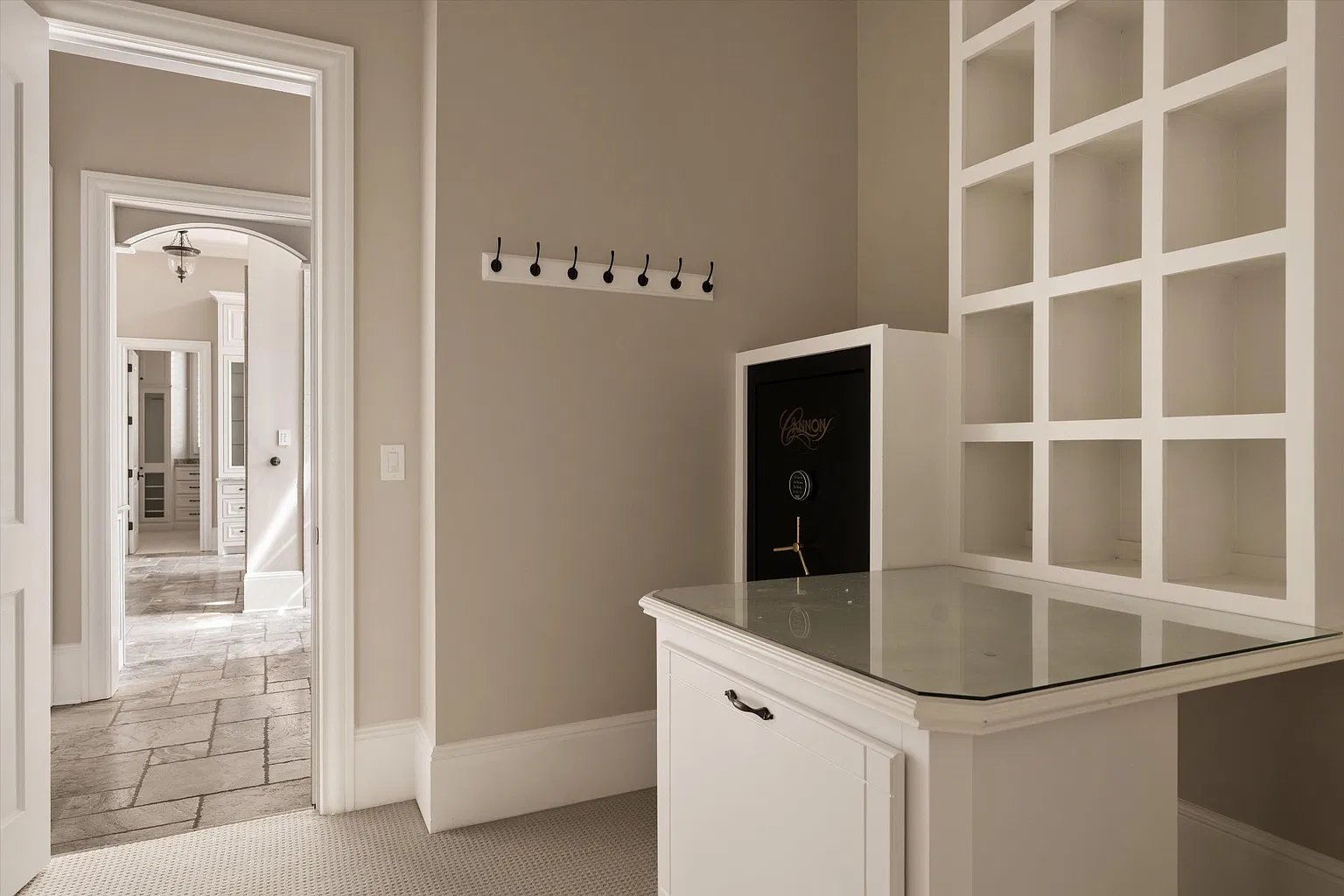 The second, smaller closet features built-in cubbies, a counter-height storage island, and a concealed safe.