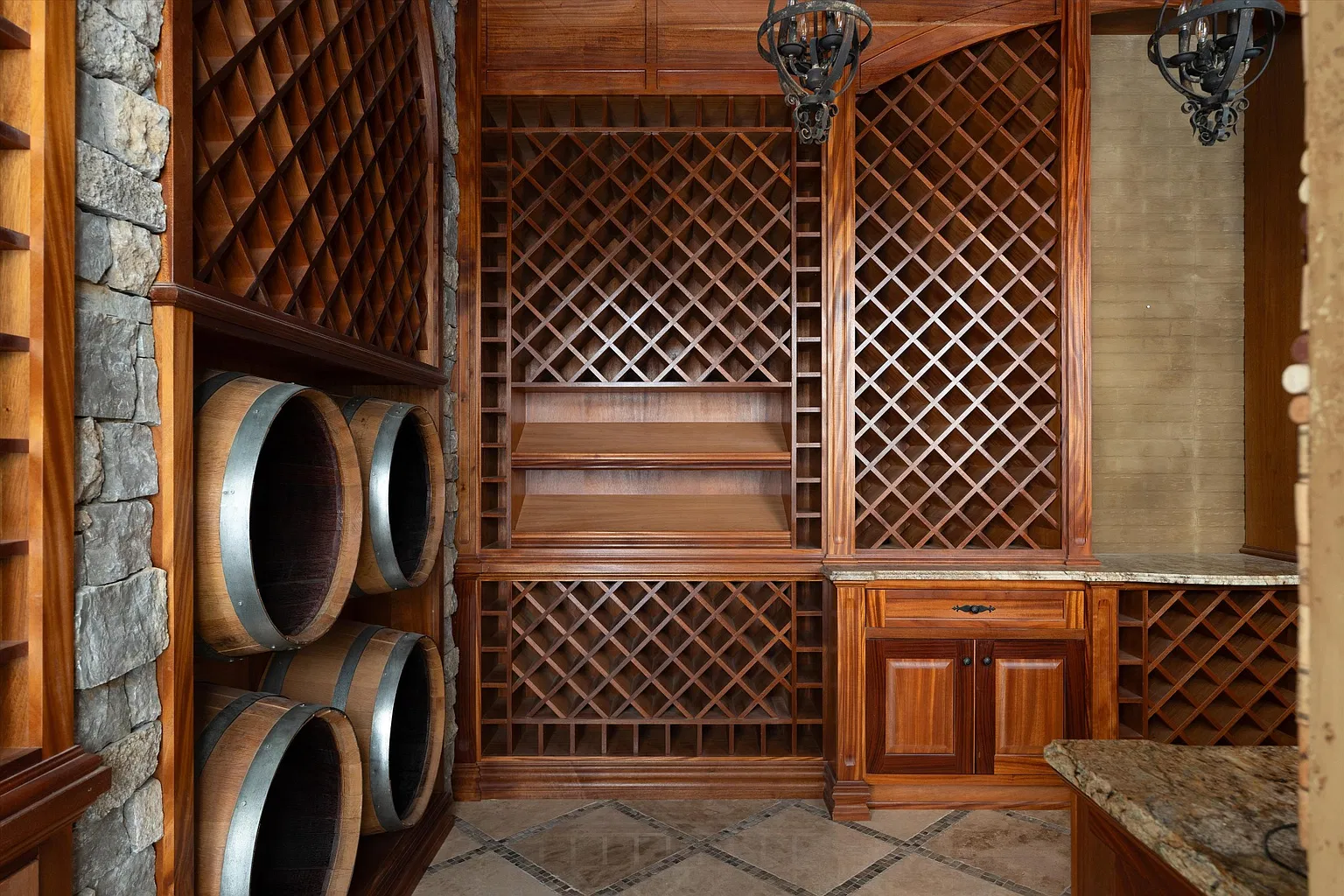 A wine cellar is lined with custom wood racks, barrel storage, and stone accents.