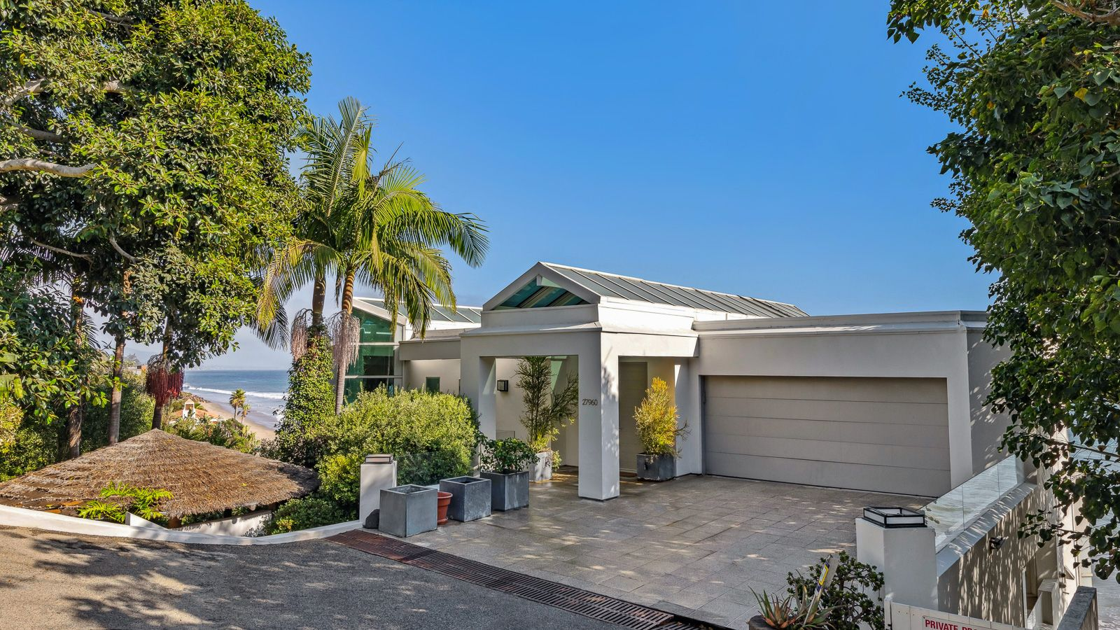 Malibu home with a two-car garage and mature landscaping that provides only a small peek at the property's ocean views.