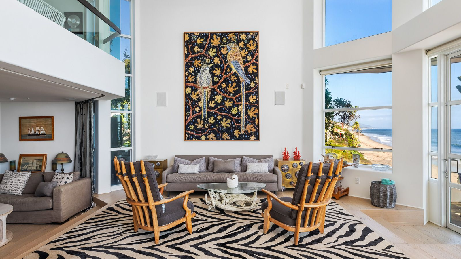 A sofa and pair of lounge chairs are gathered around a glass-topped coffee table.