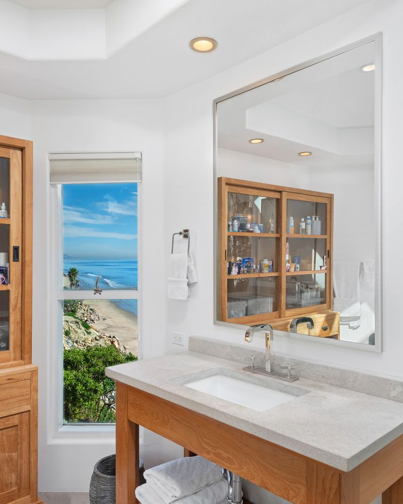 A marble topped banity with ocean view.