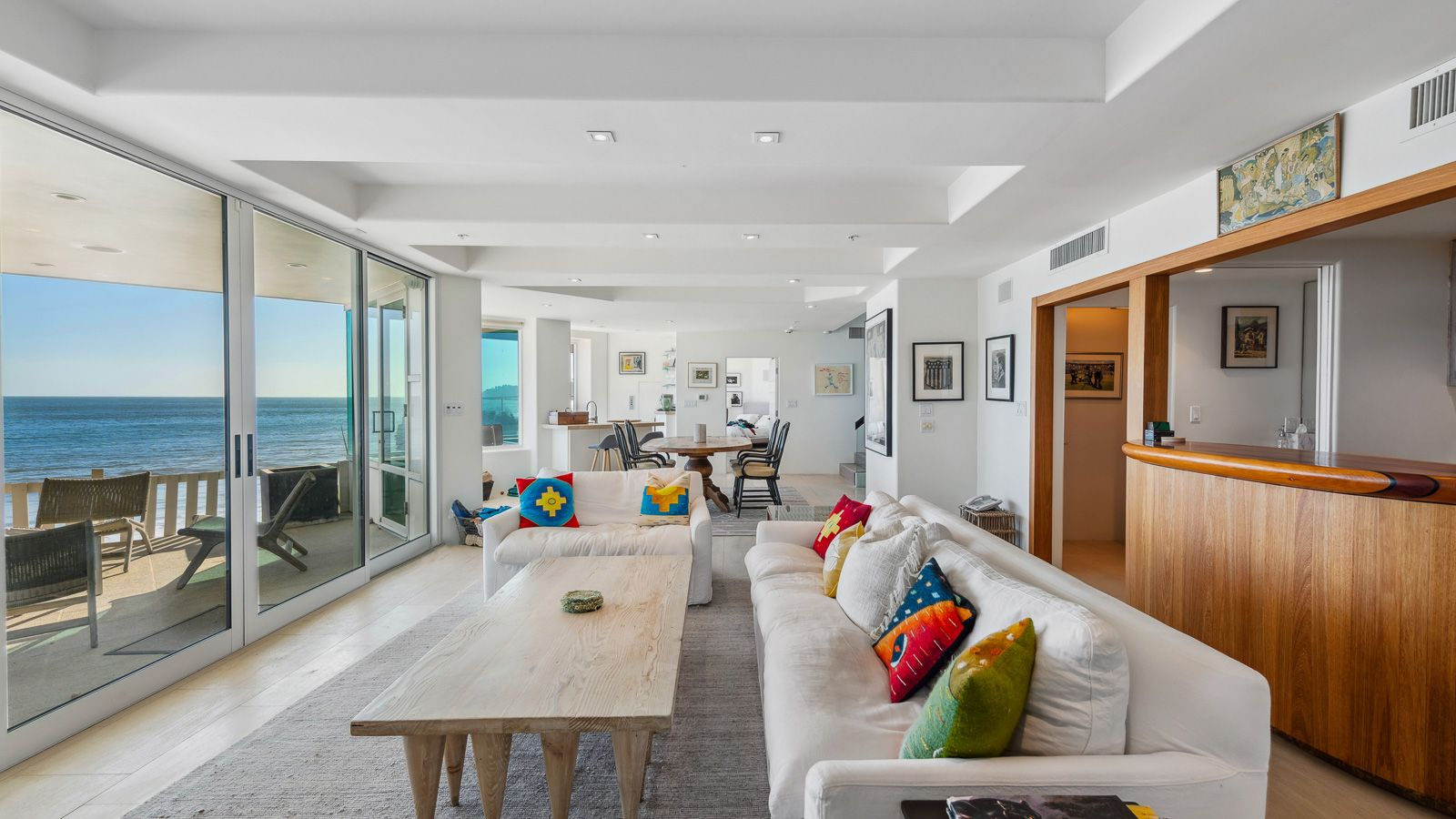 The room then widens into the family lounge, with white sofas are placed in front of the home's second kitchen facing sliding glass doors that open to an ocean-facing terrace.