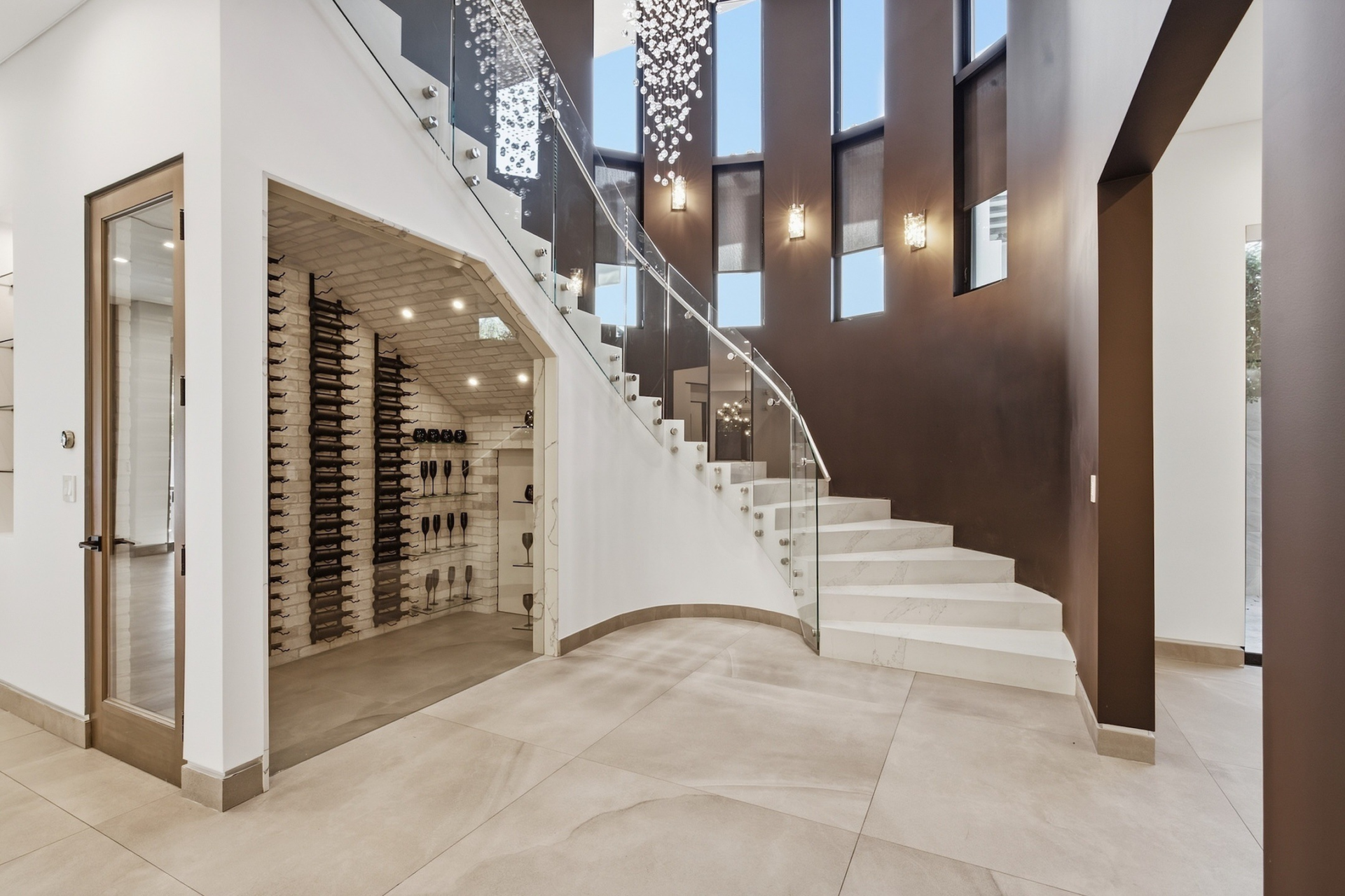 The staircase curves past a wine room tucked beneath it. 