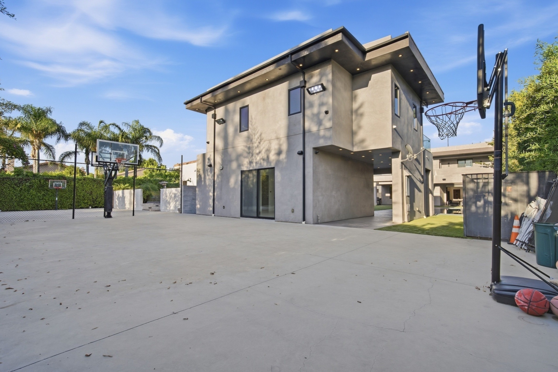 Continuing past the guesthouse brings you to the basketball court with multiple hoops and fencing.