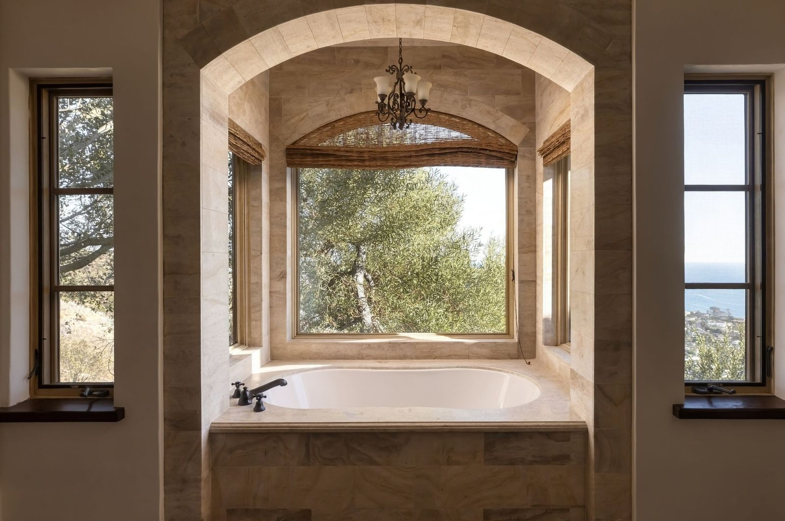 A deep soaking tub set within an arched window bay. 