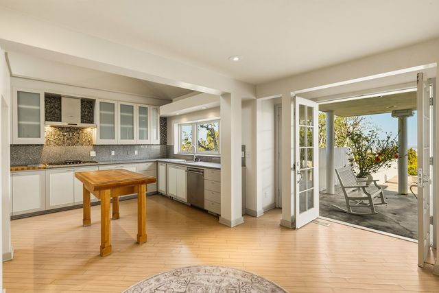 At the center of the room, a custom wood-topped table serves as a breakfast area and additional workspace, before opening to the backyard.