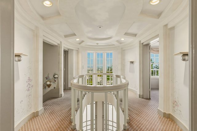 At the top of the stairs, a circular landing is surrounded by more paintings along the walls and a clouded sky overhead before heading into the bedrooms.
