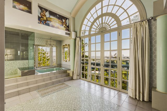 The bathroom is the most dramatic room in the suite, with a full wall of arched windows that open to views of Los Angeles.