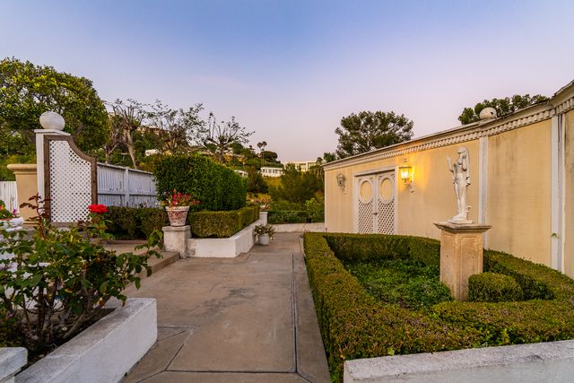 Behind one side of the fence, you'll find the pool house sitting in a tucked-away courtyard.