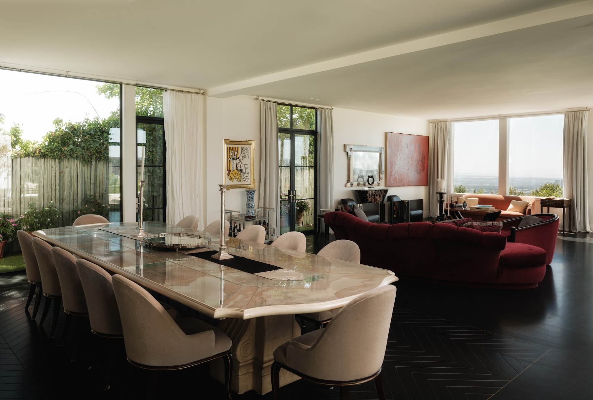 The dining area sits towards the front of the room beside tall windows and garden-facing doors.
