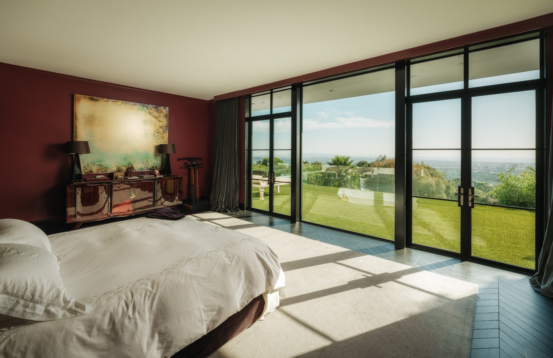 The room itself is kept relatively simple, allowing the view to remain the main focus while the dark red walls add contrast to the bright space.