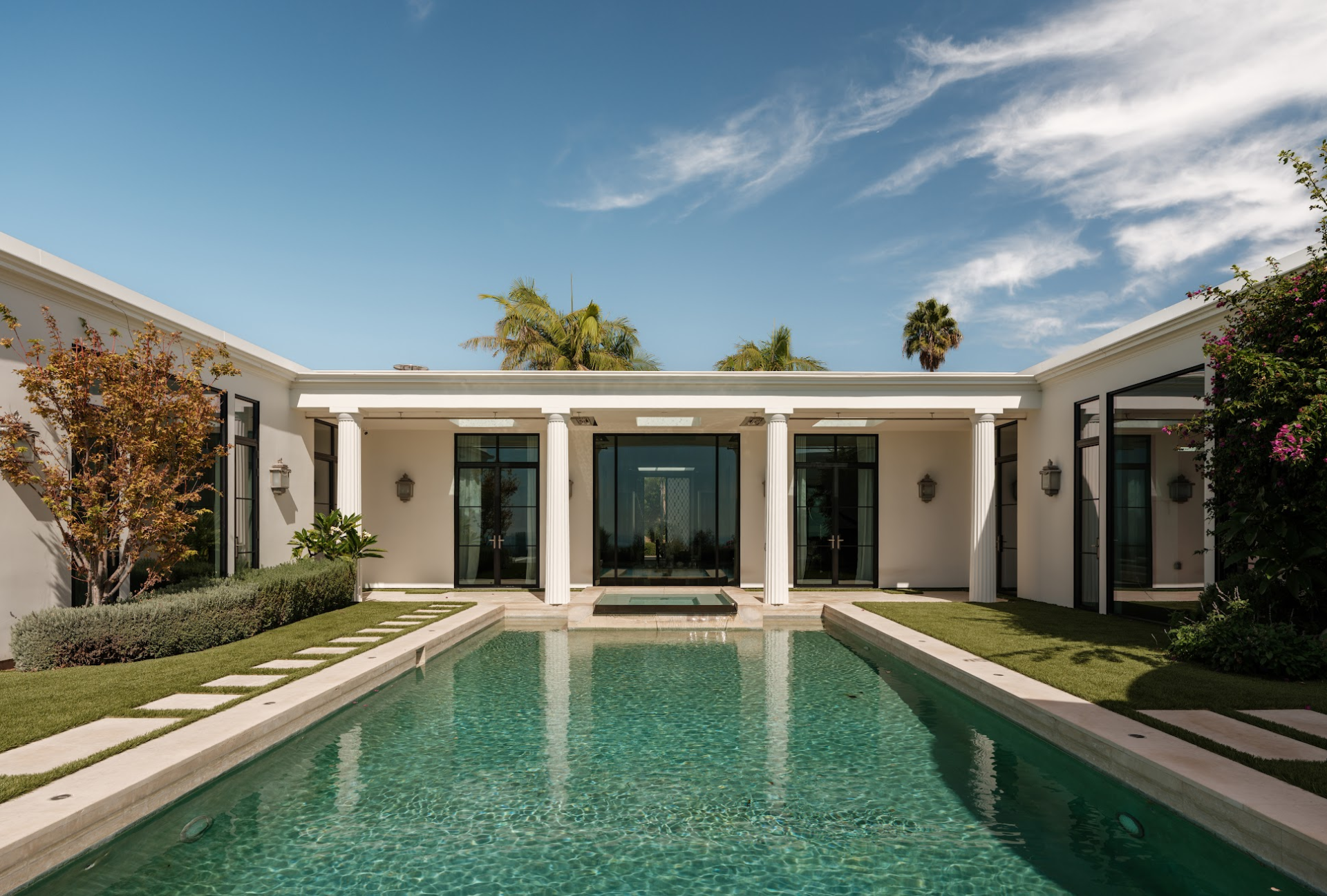 Landscaped paths and lawn run around the pool.
