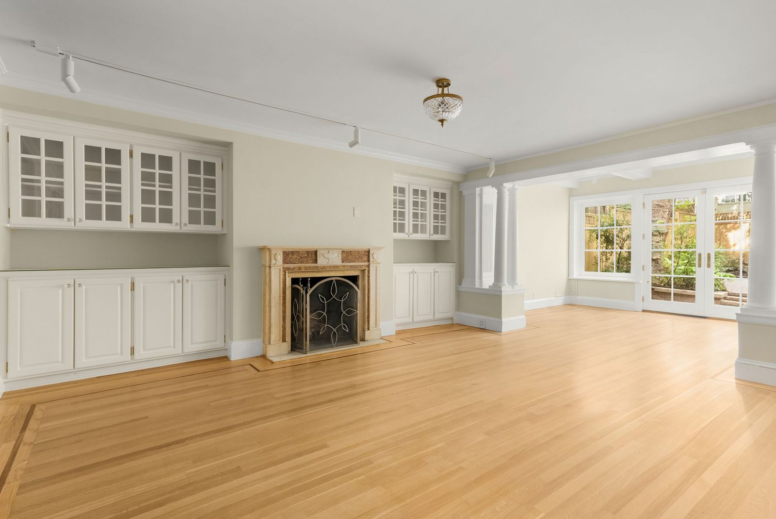 A formal dining room where a fireplace sits between built-in white cabinetry.