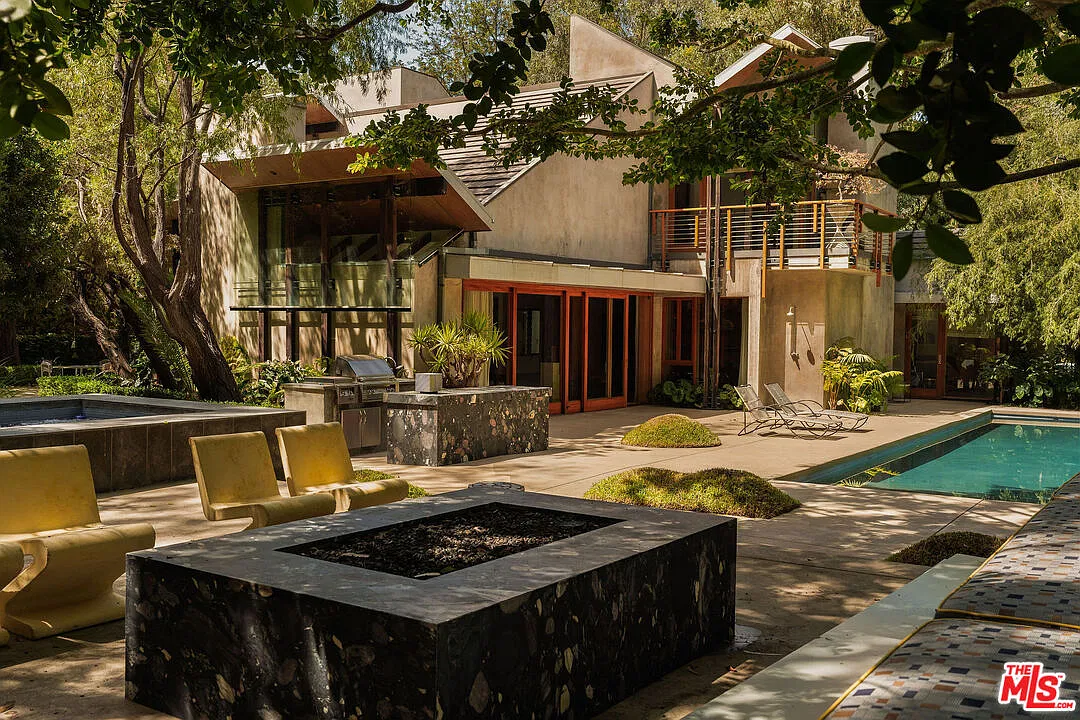 Firepit lounge with views of the pool and outdoor kitchen.