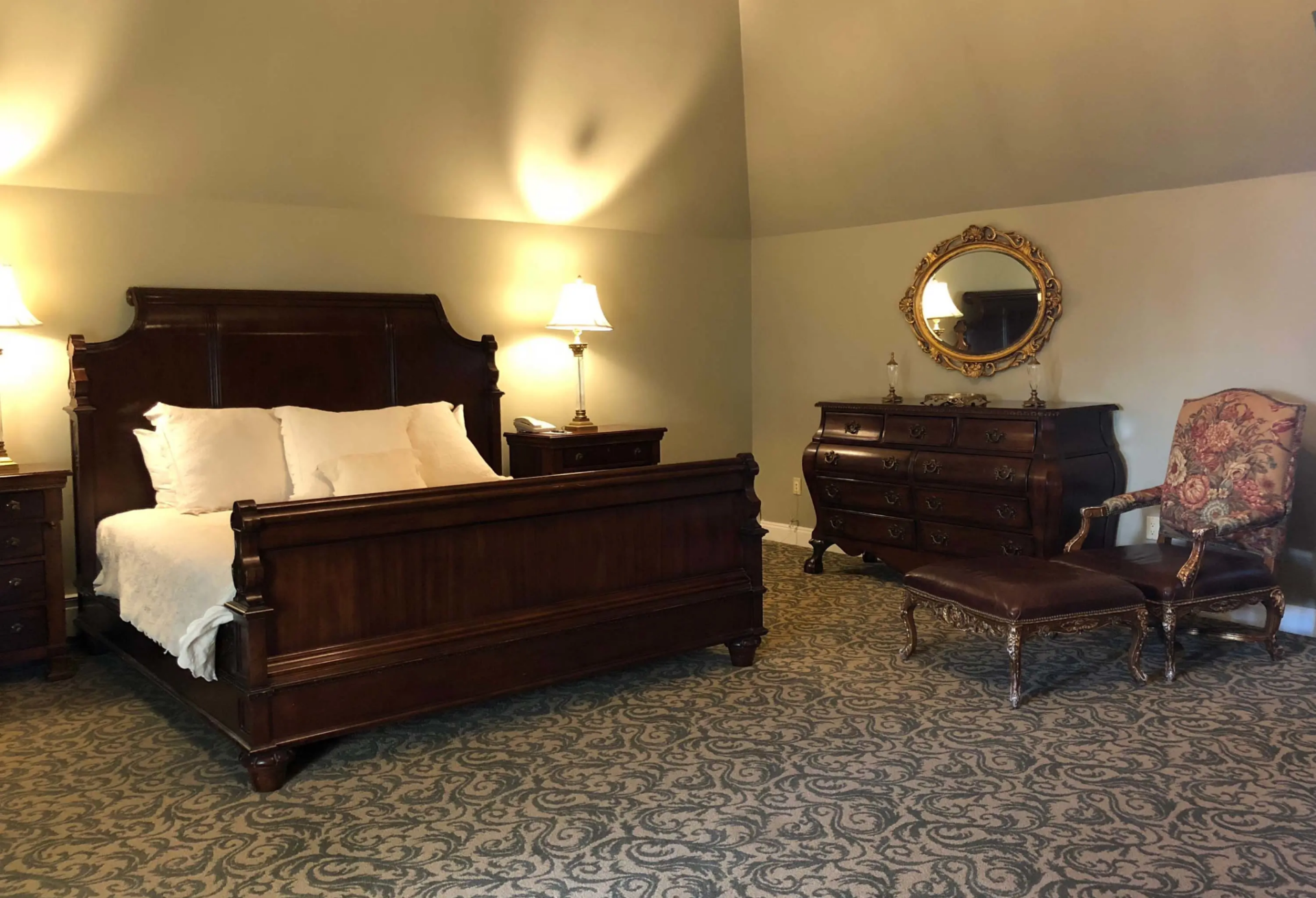 A wide doorway leads directly into the bedroom, which has a simple design that includes the bed, a dresser, and a reading chair.