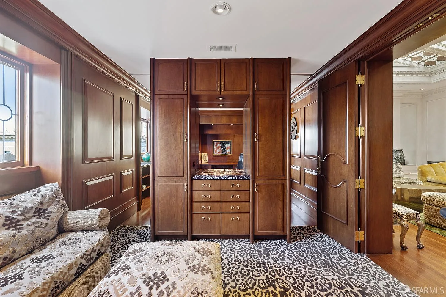Between the two doorways, a wall of built-in cabinetry sits along the opposite side of the fireplace.