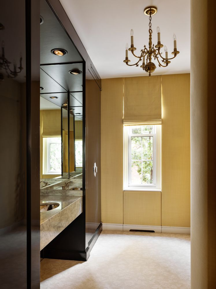 The suite's bathroom pairs bright yellow walls with a marble-topped vanity and mirrored cabinetry.