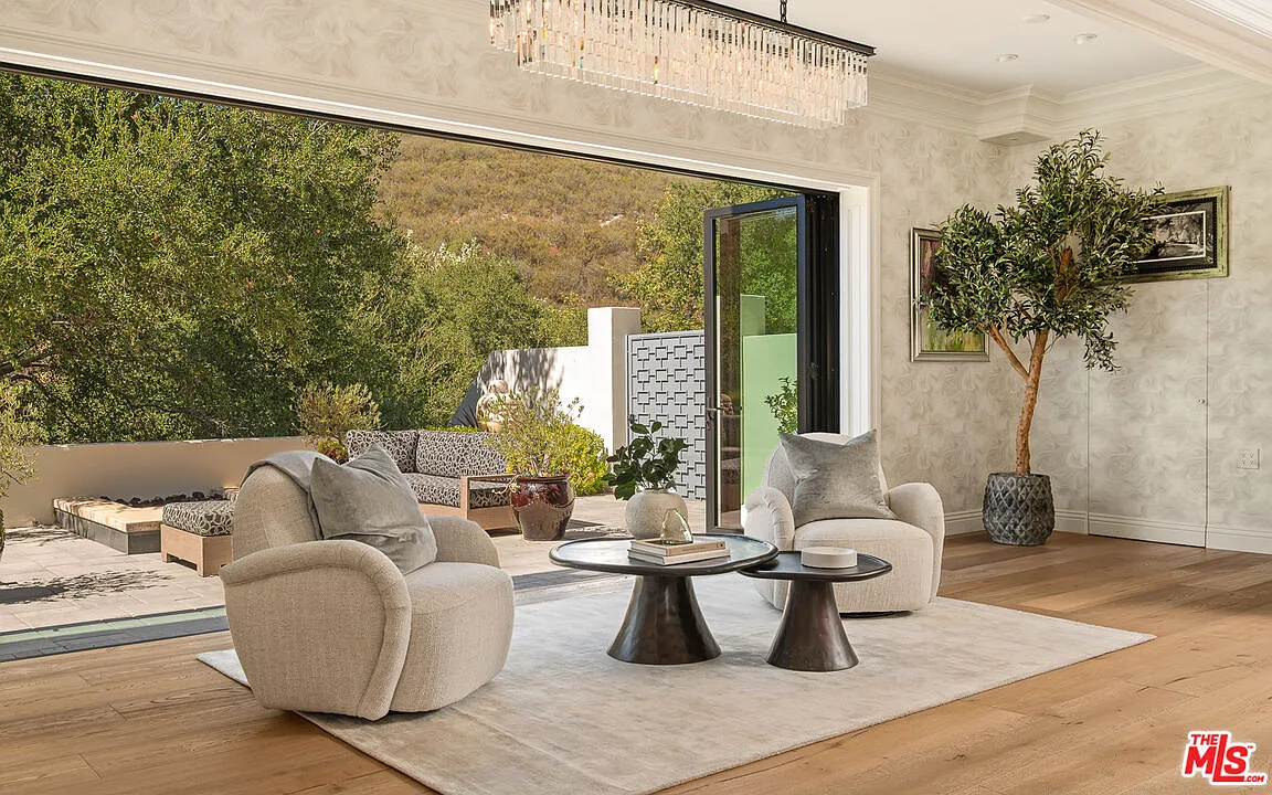 Oversized folding glass doors open directly to outdoor terraces.